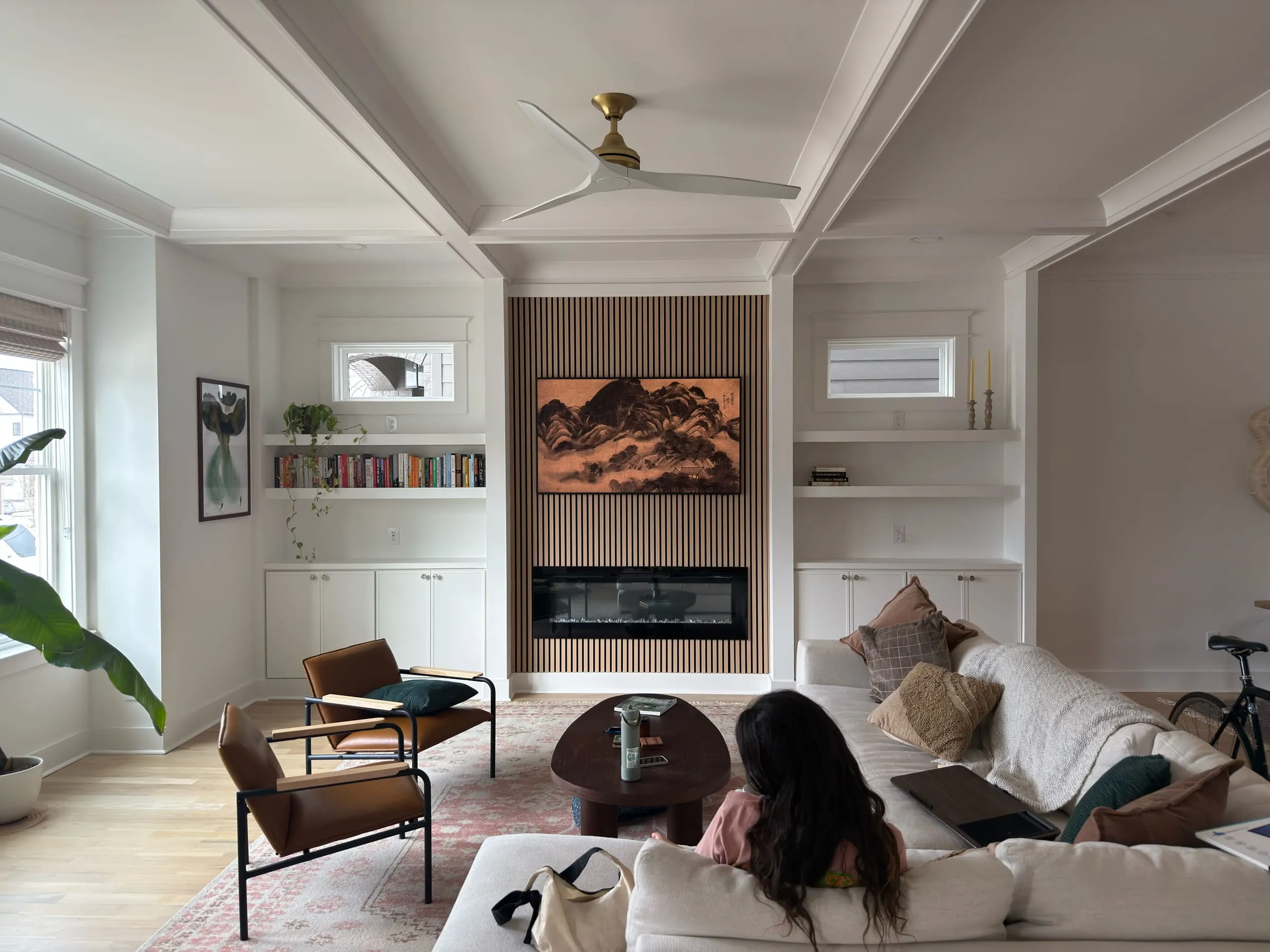 The Edsel living room with fireplace, built-ins, and warm evening light